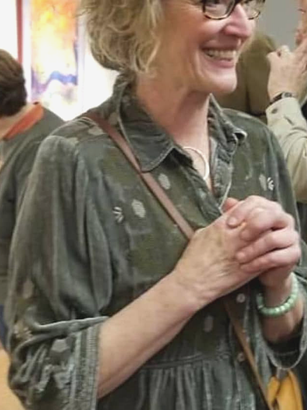 woman in crowded art gallery with circle necklace